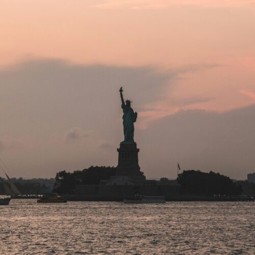 sunset view of statue of liberty on ellis island