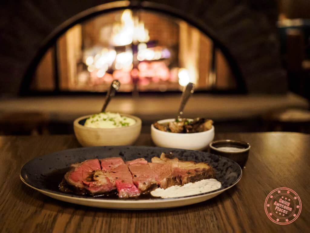 bluebird restaurant and lobby bar with prime rib and sides in front of fire place