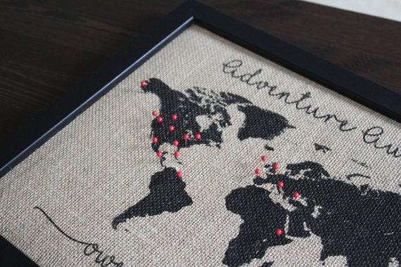 burlap world map close up with red pins