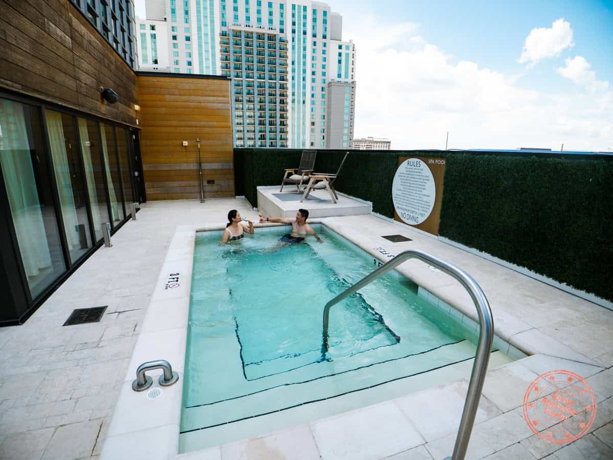 couple enjoying the jw spa jacuzzi with sparkling wine