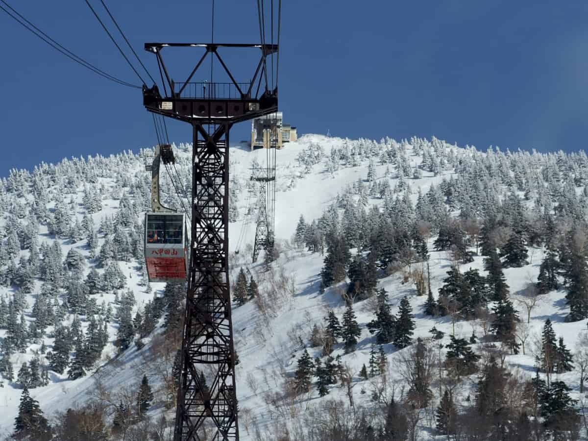 hakkoda ropeway cable car going over snow covered pines below