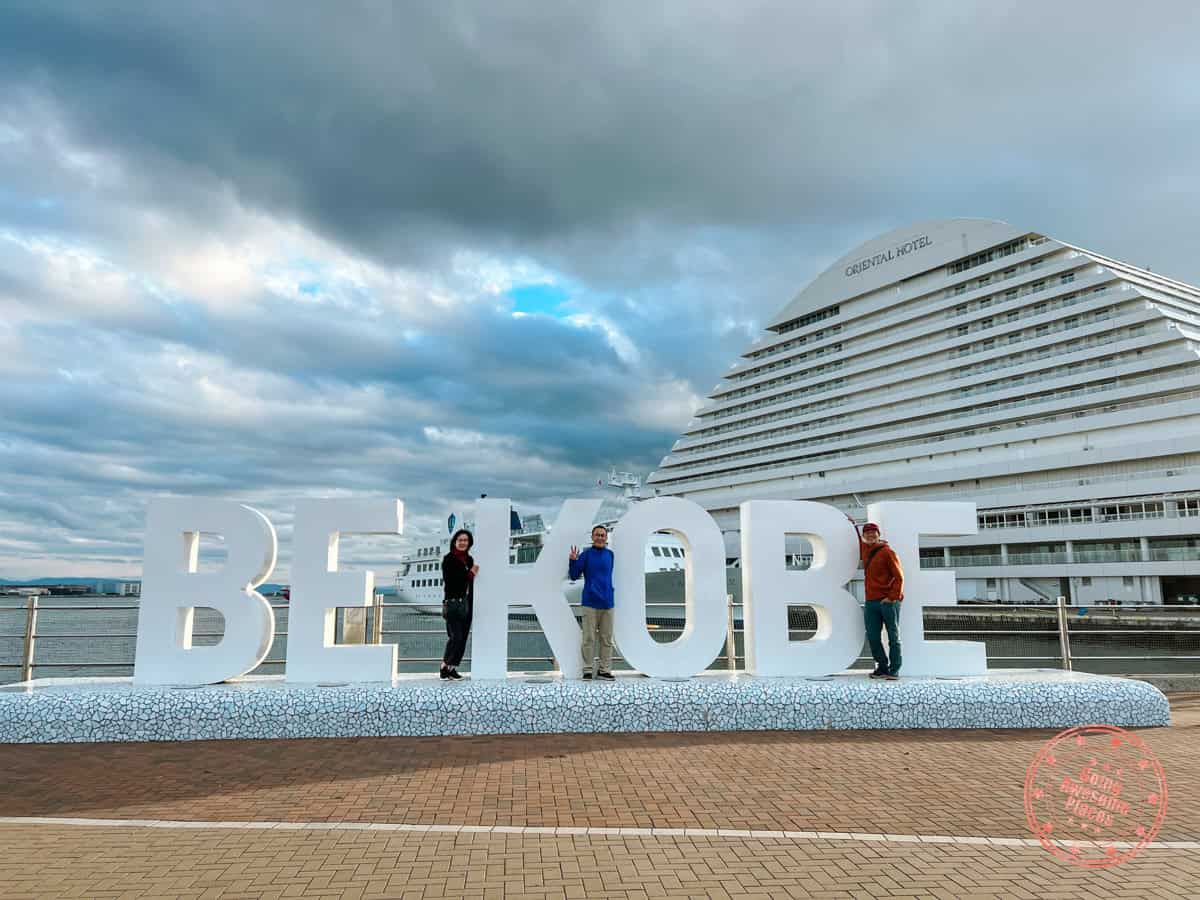 family of 3 posing in front of the harborland be kobe sign