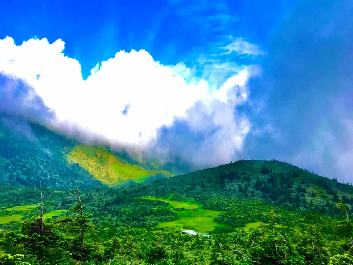 clouds over rolling green hills in aomori