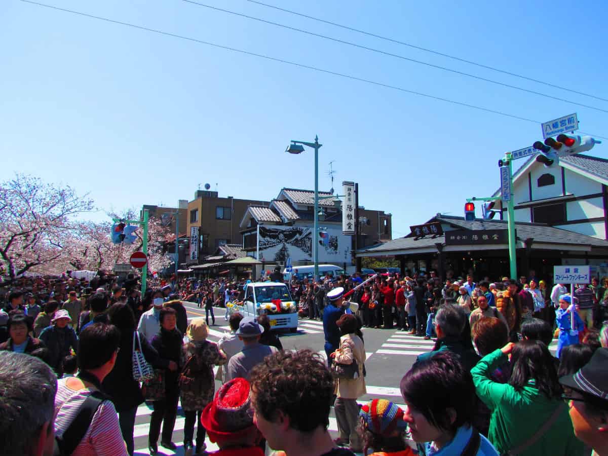 crowded street lined with people to see parade for kamakura matsuri