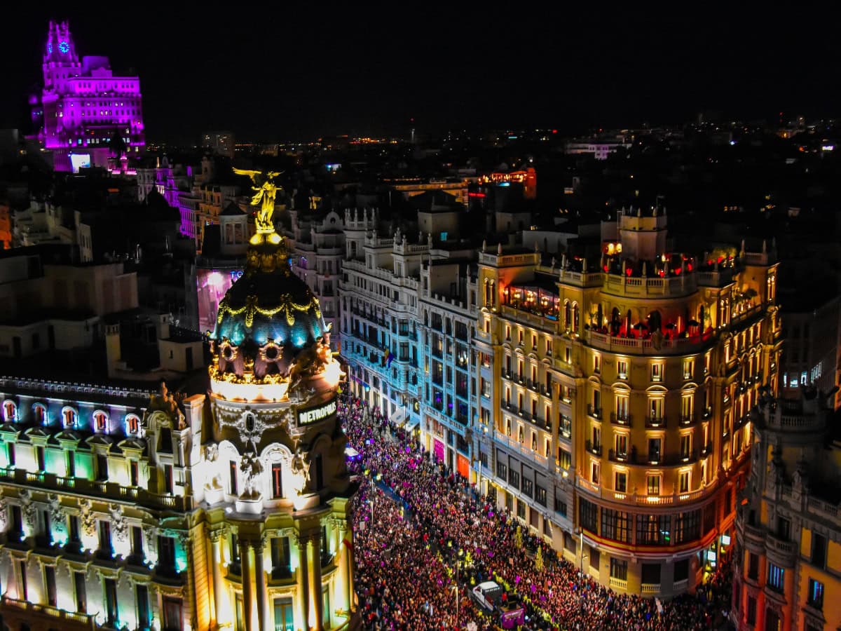 glowing buildings and crowded street in the city of madrid at night