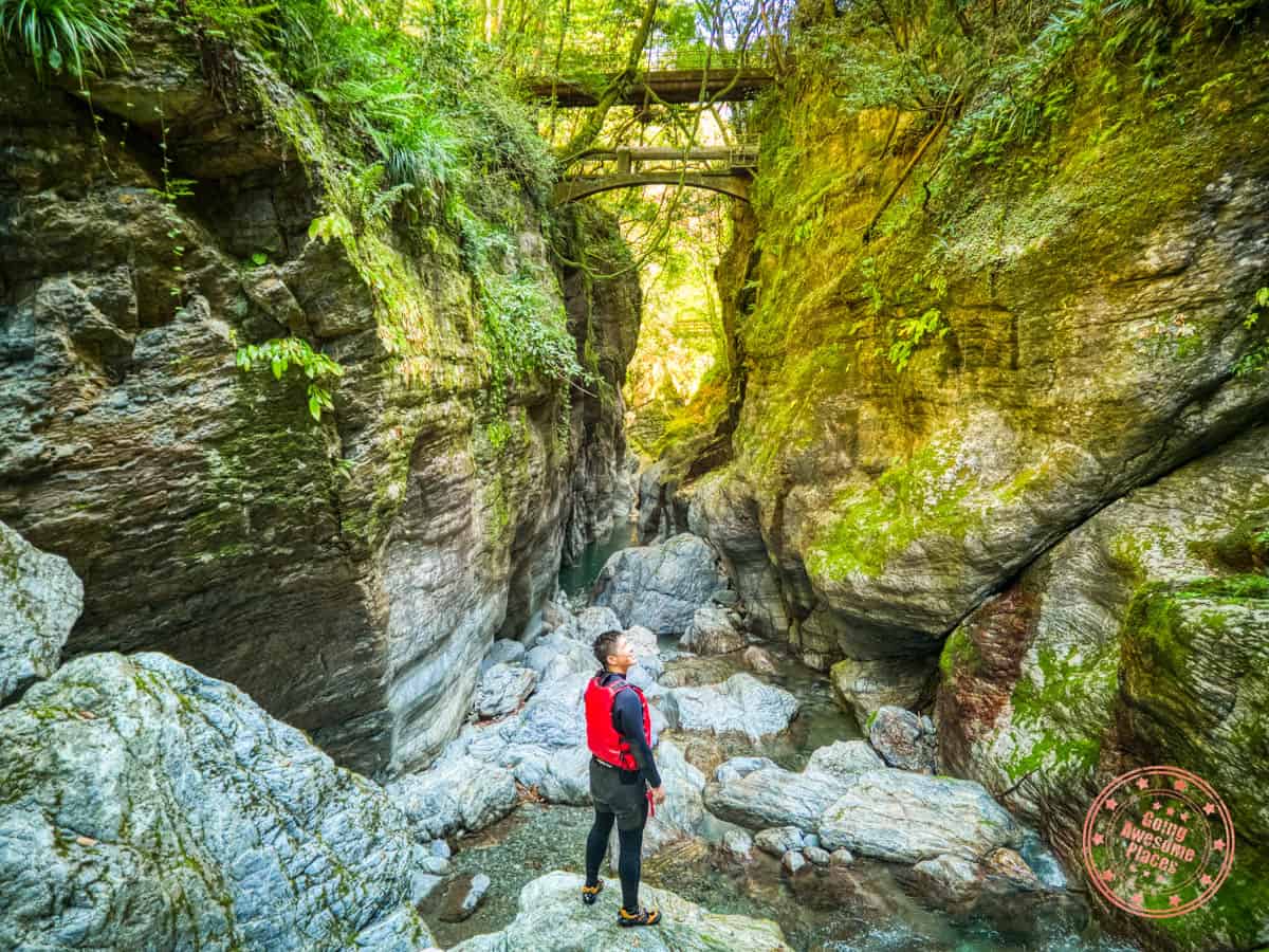 man standing on rocks in nakatsu gorge during canyonining experience with niyodo adventure