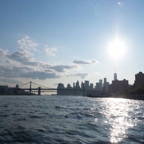 view of new york beyond bridge from water