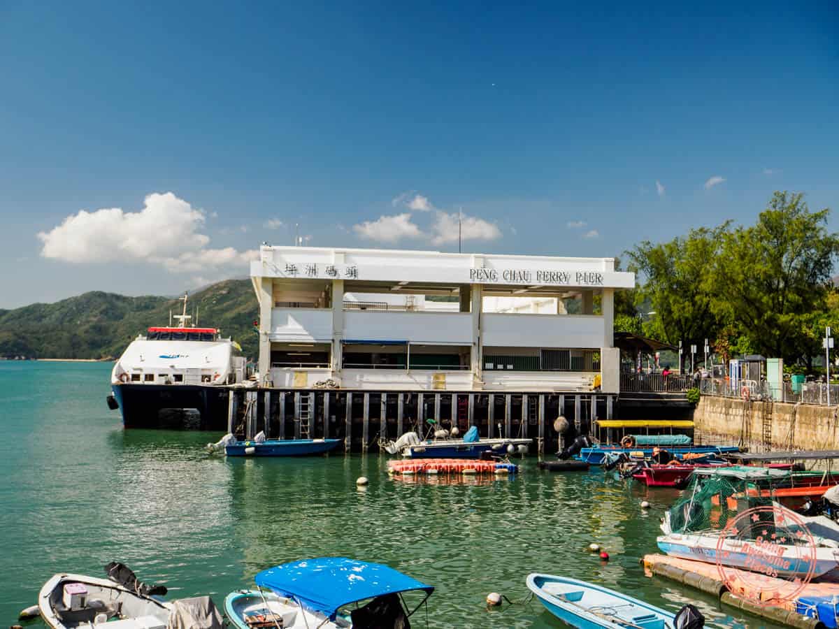 peng chau ferry pier with ferry docked and small fishing boats in the foreground