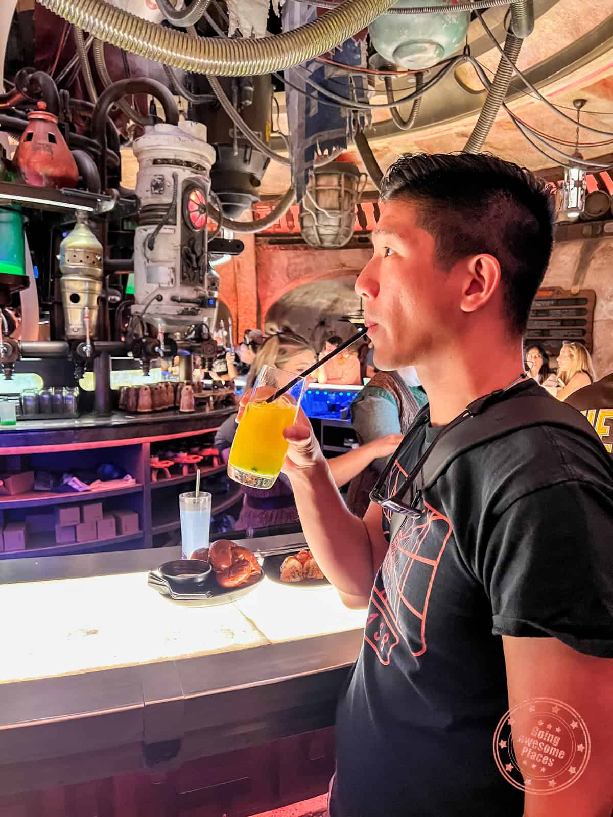 sipping on cocktail at the bar in oga's cantina of galaxy's edge