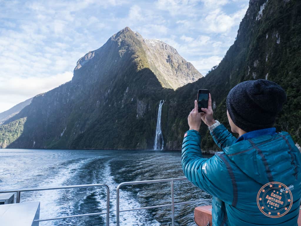 taking phone photos of milford sound on guided new zealand cruise