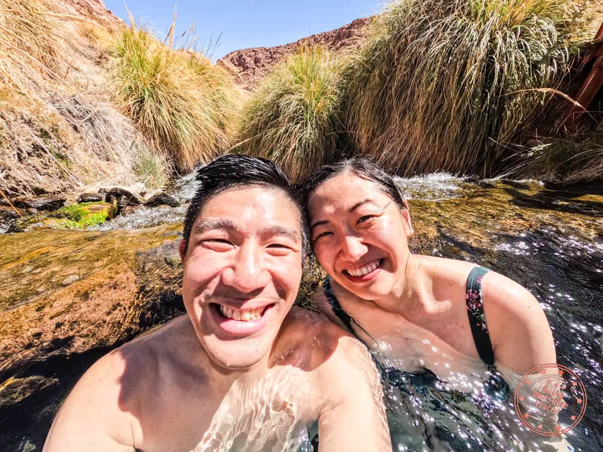 asian couple enjoying termas de puritama in atacama