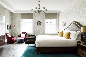 where to stay in new york the beekman hotel suite with king bed, seating chairs and chandelier 