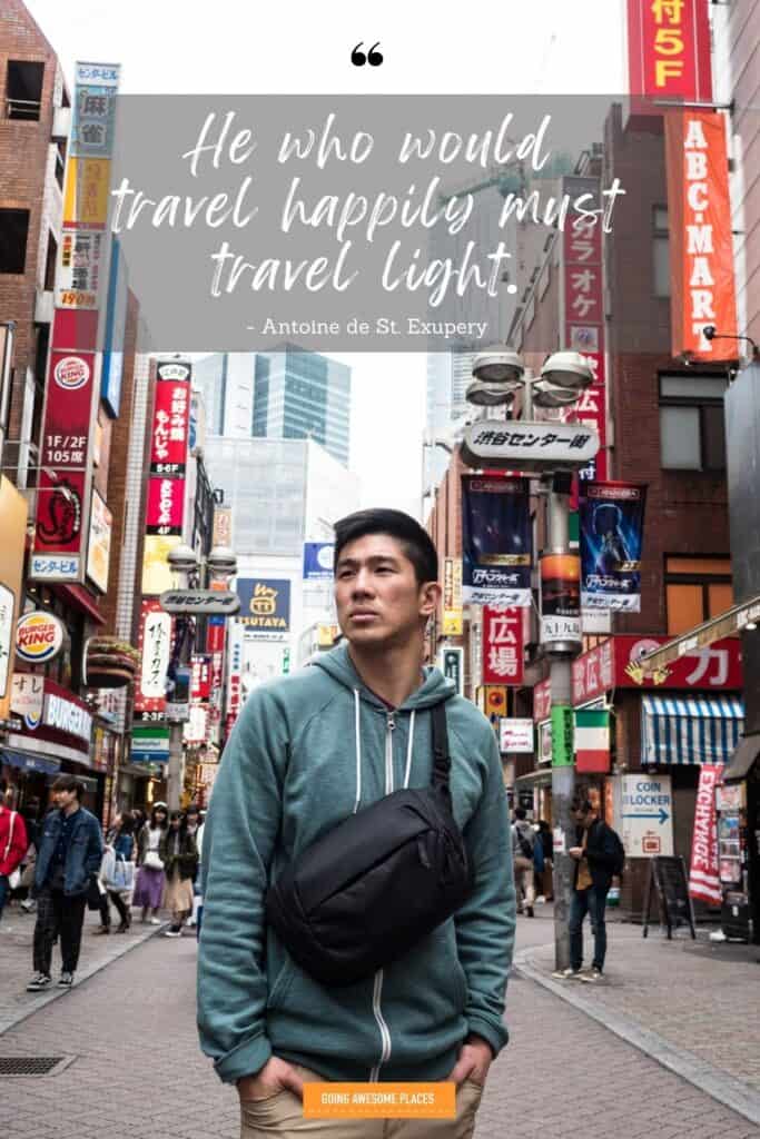 he who travel happily must travel light travel quote by antoine de Sst. exupery with man posing in tokyo