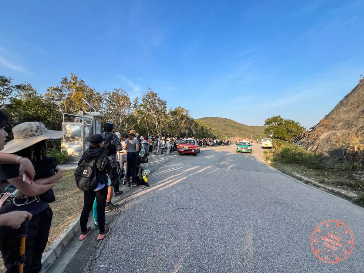 extremely long queue waiting for bus to leave high island reservoir east dam in the afternoon