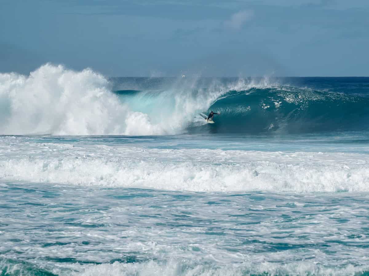 where to stay oahu man surfing wave off of oahu.