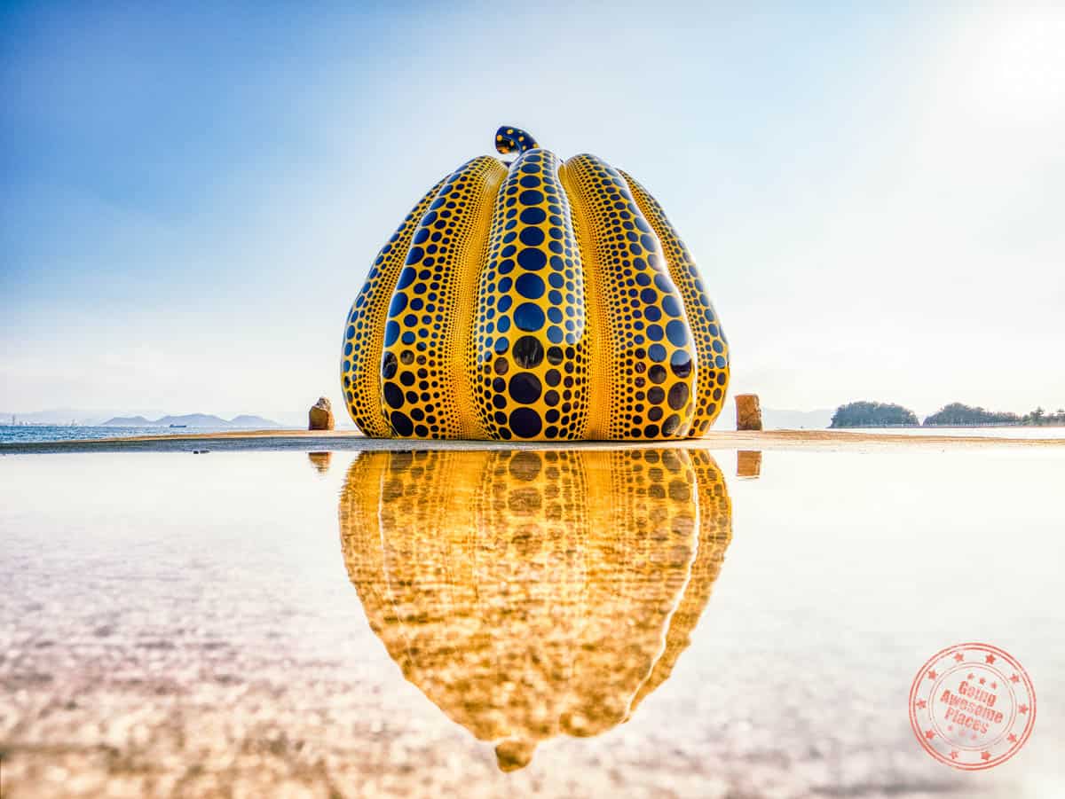 yayoi kusama sculpture yellow pumpkin reflection in the water on naoshima island